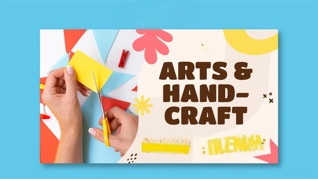 A close-up of two hands holding yellow paper and yellow-handled scissors, cutting shapes in an arts and craft workspace filled with colorful paper cutouts in red, blue, and white geometric patterns, decorated with a pink floral shape, a red clothespin, and a yellow star burst — illustrating creativity and DIY handcraft activity.