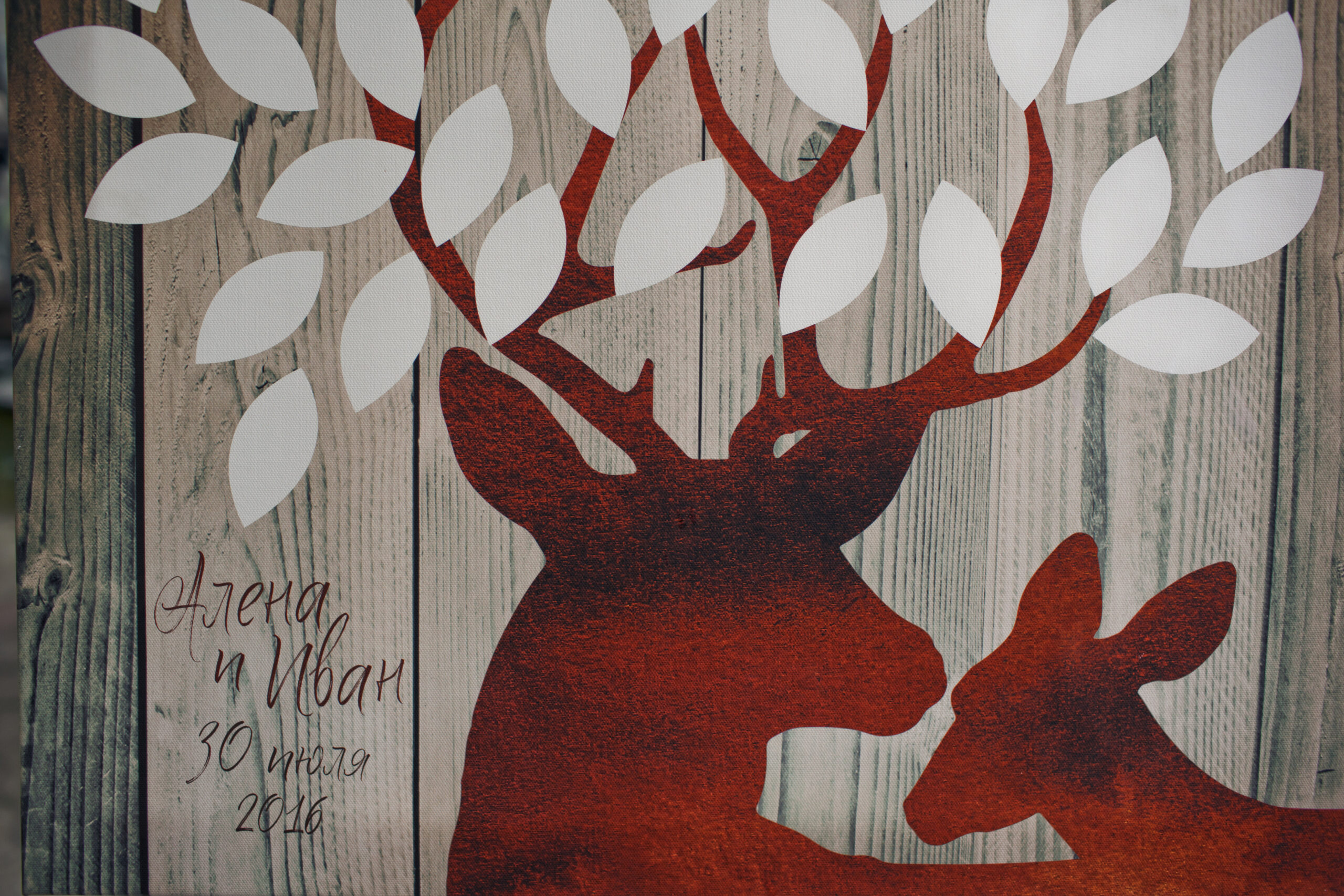 Red deers with white leaves painted on wooden board